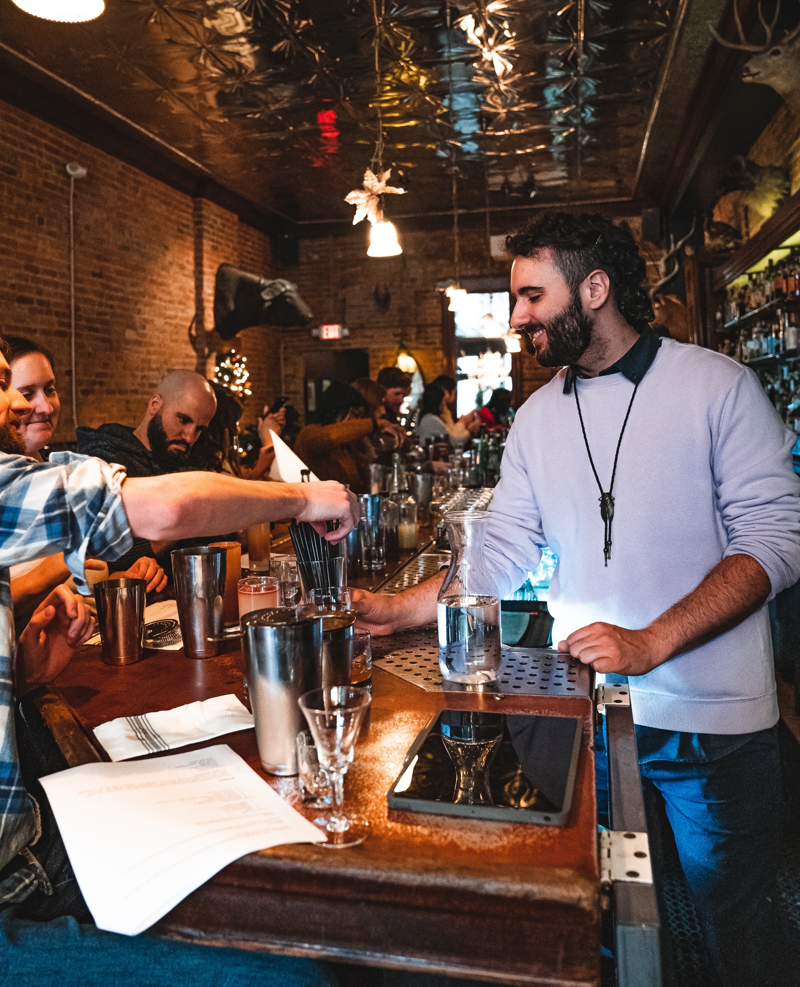Bartender teaching guests behind the bar at Sugar House Detroit