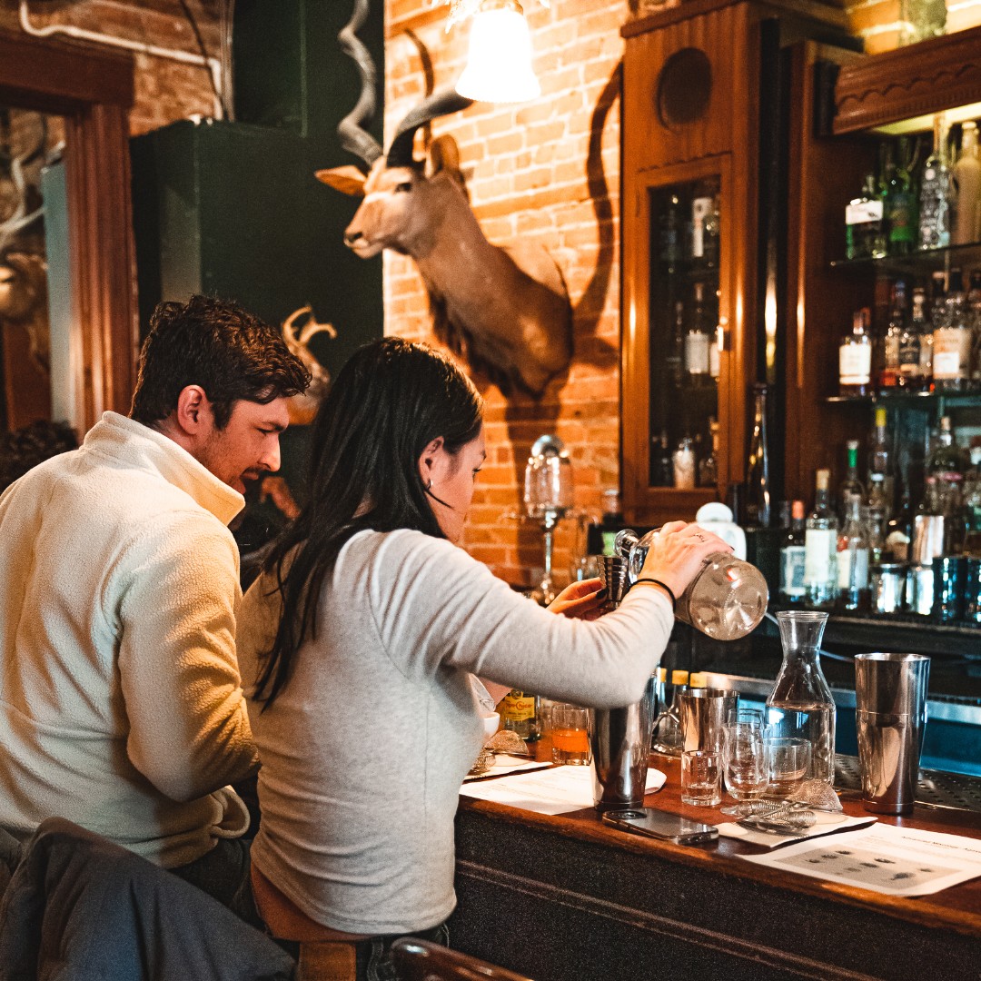 Couple making cocktails together during a Sugar House class